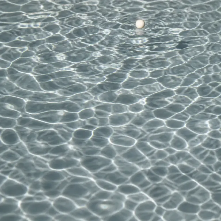 Macro photograph of gently rippling water in side window light with a tiny ceramic scale bead